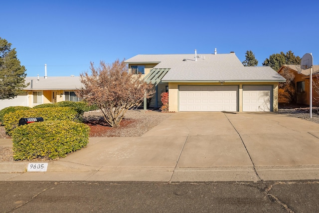 view of front facade with concrete driveway, an attached garage, and stucco siding