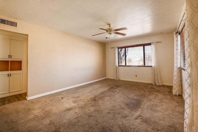 carpeted spare room featuring ceiling fan, a textured ceiling, visible vents, and baseboards