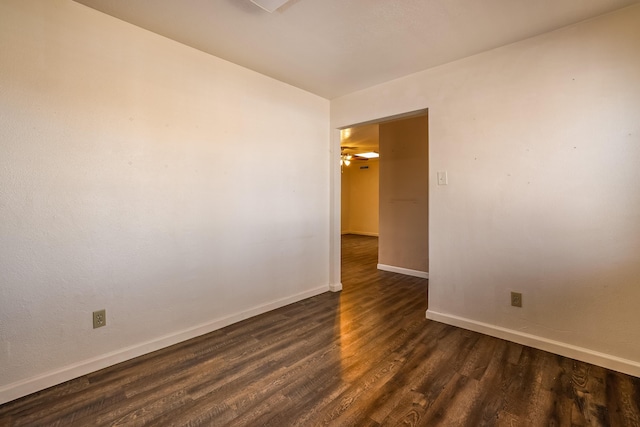 spare room featuring dark wood finished floors and baseboards