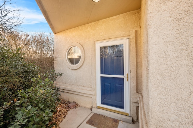 view of exterior entry featuring stucco siding