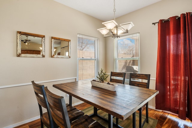 dining area featuring baseboards, dark wood finished floors, and a notable chandelier