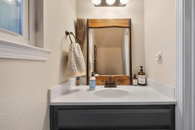 bathroom featuring a textured wall and vanity