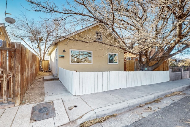 view of front facade with a fenced front yard and stucco siding