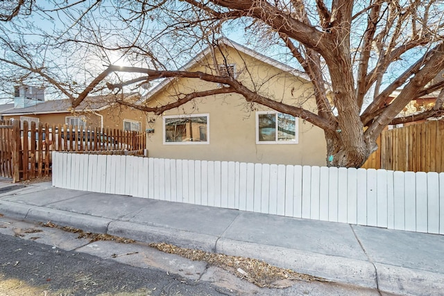 view of home's exterior with a fenced front yard and stucco siding