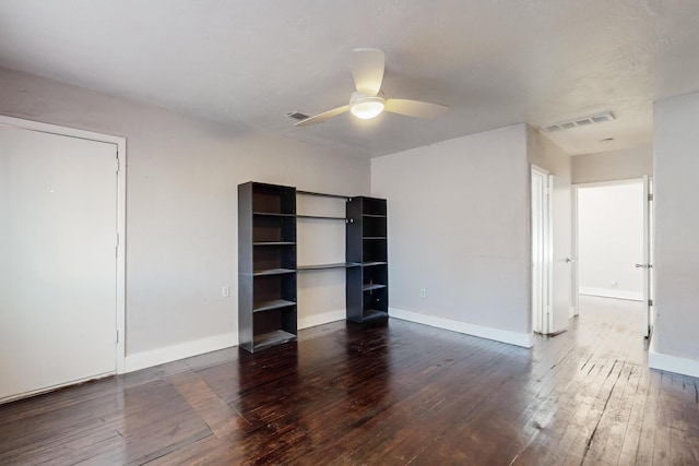 spare room featuring a ceiling fan, baseboards, visible vents, and dark wood-type flooring