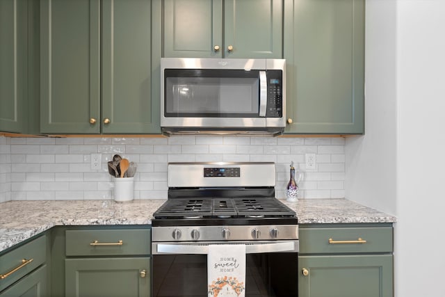 6052 Nauman Dr SE, Albuquerque, NM 87106 - kitchen featuring light stone countertops, appliances with stainless steel finishes, green cabinets, and decorative backsplash