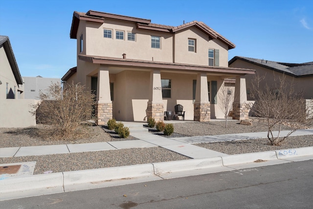 6052 Nauman Dr SE, Albuquerque, NM 87106 - view of front of home featuring stone siding, a porch, a tiled roof, and stucco siding