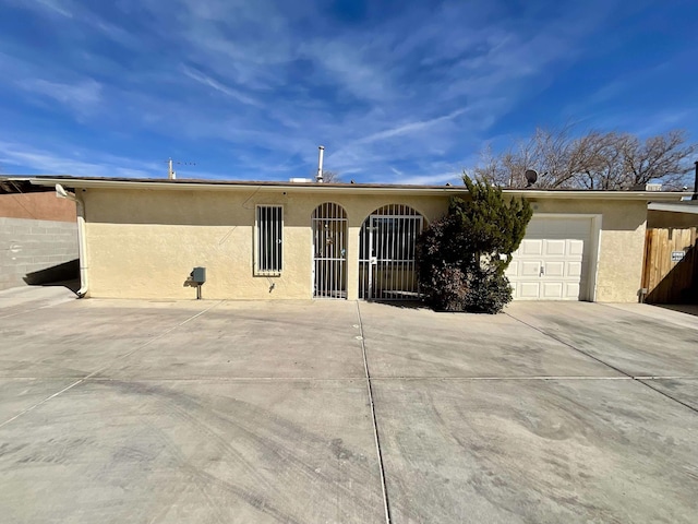 single story home with an attached garage, concrete driveway, and stucco siding