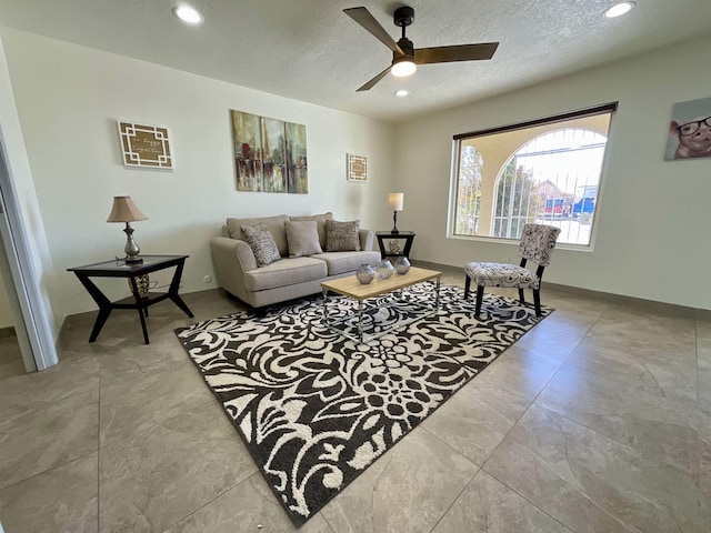 living room with recessed lighting, ceiling fan, a textured ceiling, and baseboards