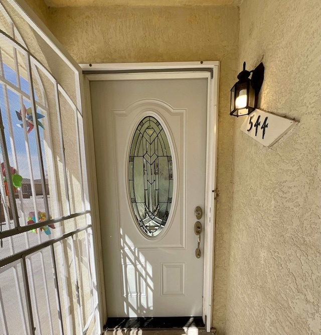 entrance to property featuring stucco siding