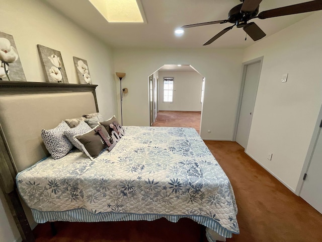 carpeted bedroom with arched walkways, a ceiling fan, and recessed lighting