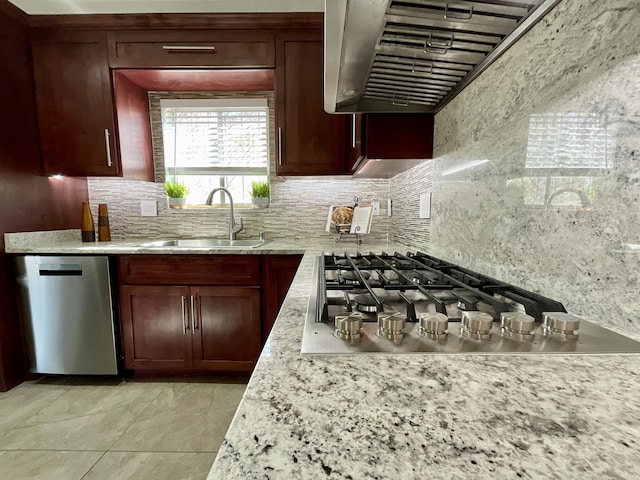 kitchen with stainless steel appliances, premium range hood, a sink, and decorative backsplash