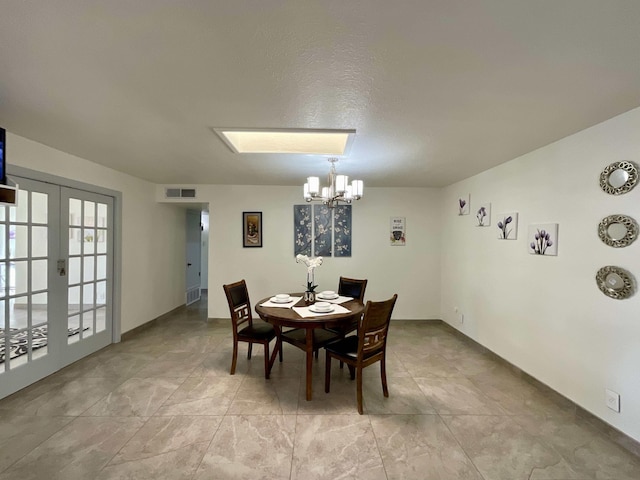 dining room with visible vents, a chandelier, and french doors