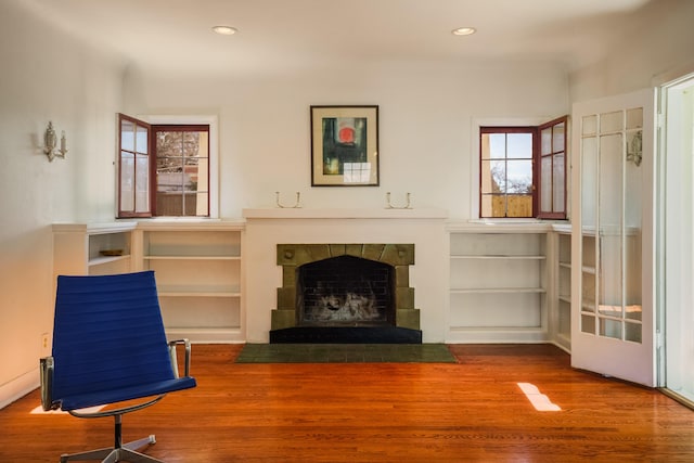 sitting room with a fireplace, plenty of natural light, wood finished floors, and recessed lighting