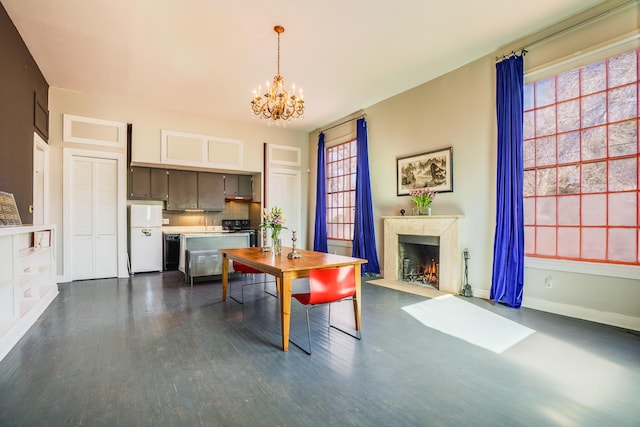 dining area featuring baseboards, dark wood-style flooring, a premium fireplace, and a notable chandelier