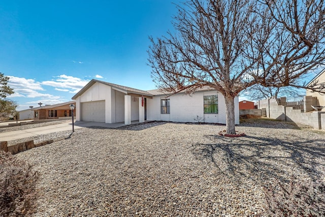 view of front of property with a garage, concrete driveway, brick siding, and fence