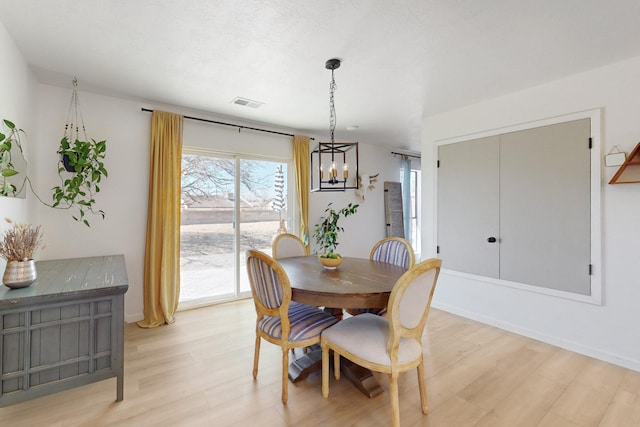 dining room featuring light wood finished floors and visible vents