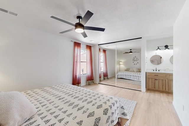 bedroom featuring light wood-style flooring, visible vents, ceiling fan, and baseboards