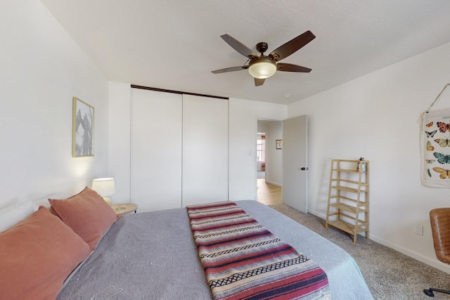 bedroom featuring ceiling fan, a closet, baseboards, and carpet flooring