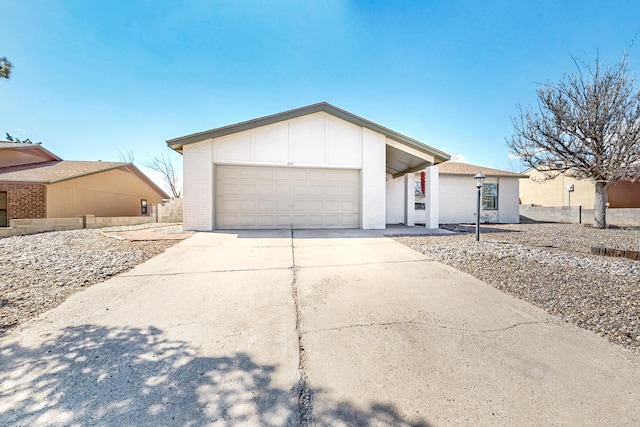 view of front of home featuring driveway, an attached garage, and brick siding