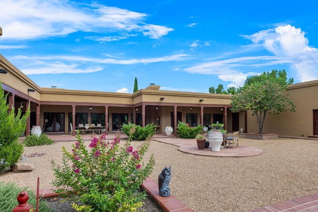 back of property with a patio area and stucco siding