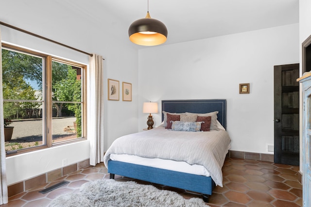 bedroom featuring baseboards, visible vents, and dark tile patterned flooring