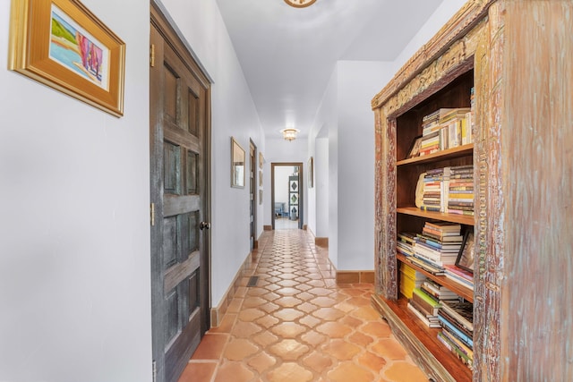 hallway featuring baseboards and built in features