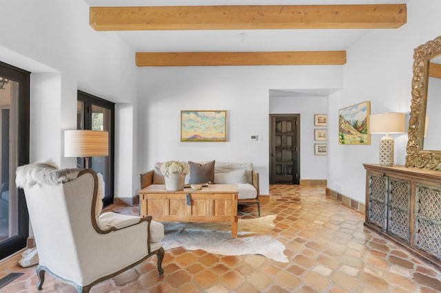 living room with beamed ceiling, visible vents, and baseboards