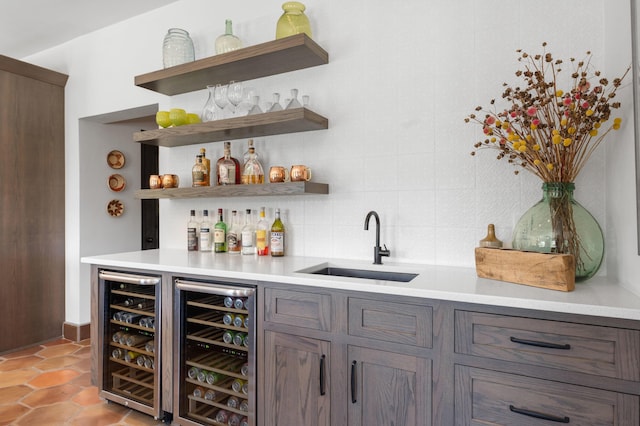 bar featuring tasteful backsplash, wine cooler, a sink, and wet bar