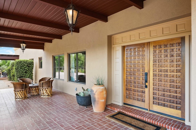 entrance to property featuring a patio and stucco siding