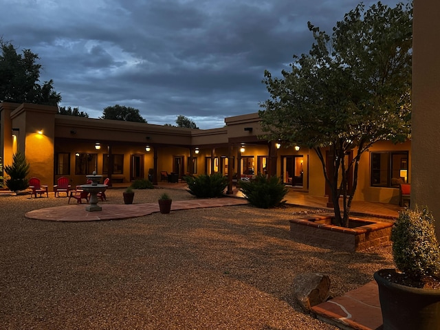 rear view of property featuring stucco siding and a patio