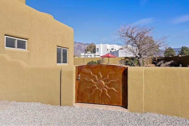 view of gate featuring fence and a mountain view