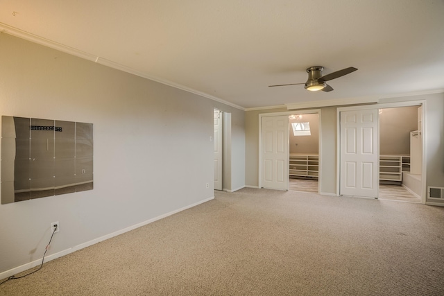 unfurnished bedroom with crown molding, a closet, light colored carpet, visible vents, and baseboards