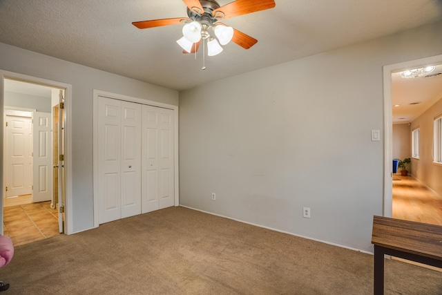 bedroom with a closet, a ceiling fan, and light colored carpet