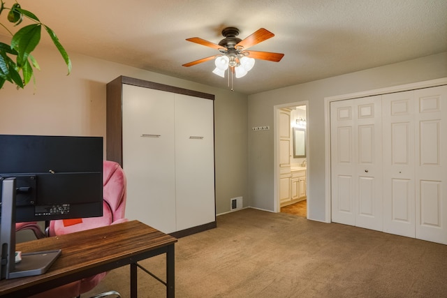 office area with light carpet, ceiling fan, visible vents, and a textured ceiling