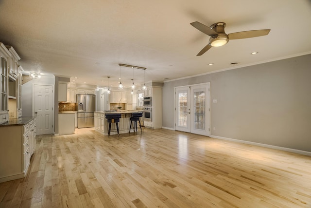 unfurnished living room with ceiling fan, baseboards, light wood-style floors, french doors, and ornamental molding