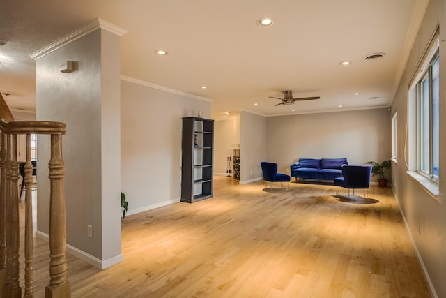 sitting room with light wood finished floors, visible vents, ornamental molding, and baseboards