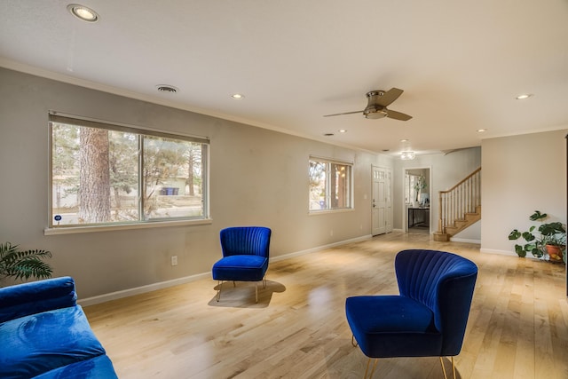 living area featuring baseboards, stairway, ornamental molding, light wood-style floors, and recessed lighting