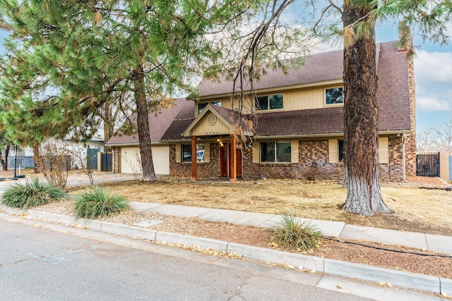 view of front facade with a shingled roof, brick siding, driveway, and an attached garage