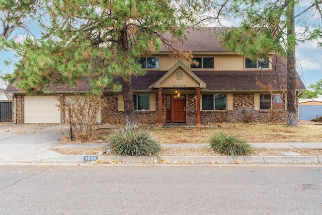 view of front of home featuring driveway, brick siding, and a shingled roof