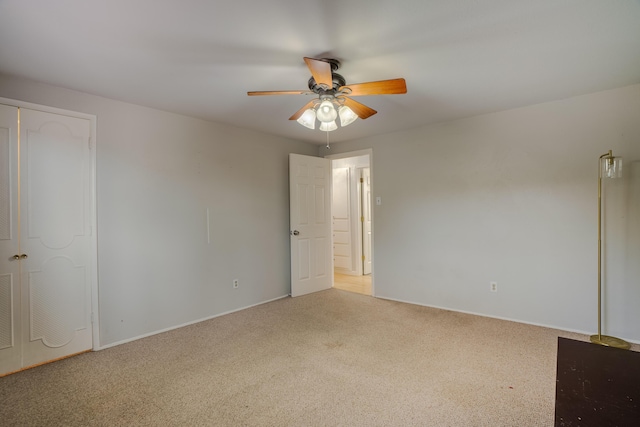 unfurnished bedroom with a closet, carpet flooring, and ceiling fan