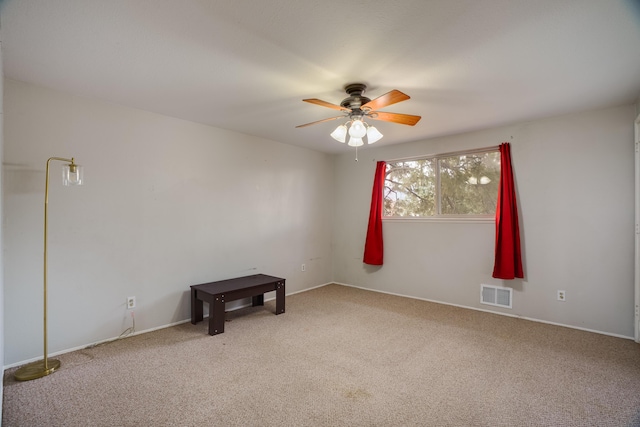 unfurnished room with carpet floors, visible vents, and ceiling fan