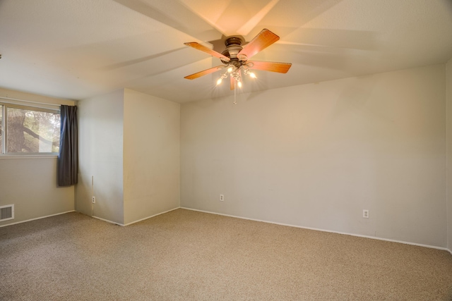 carpeted spare room with ceiling fan and visible vents