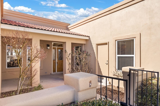 doorway to property with a tiled roof and stucco siding