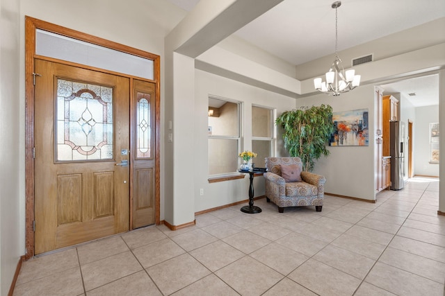 entrance foyer with baseboards, visible vents, a chandelier, and light tile patterned flooring