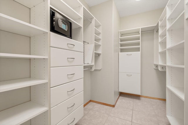 spacious closet with light tile patterned floors