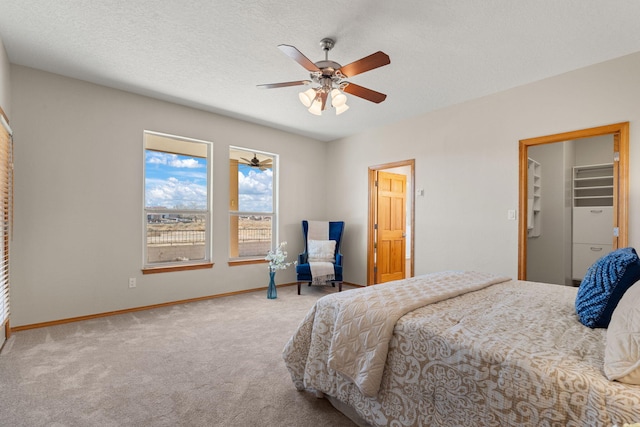 carpeted bedroom with a ceiling fan, a textured ceiling, and baseboards