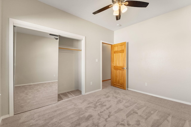 unfurnished bedroom featuring a ceiling fan, a closet, light colored carpet, and baseboards