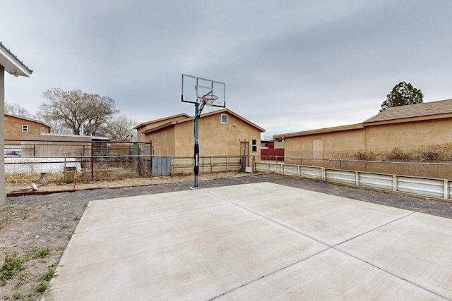 view of sport court featuring basketball hoop and fence