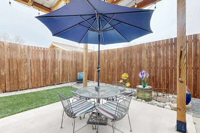 view of patio featuring outdoor dining space and fence